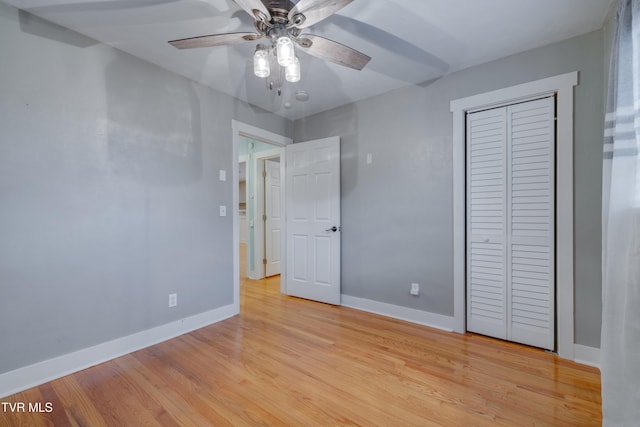 unfurnished bedroom featuring baseboards, light wood-type flooring, a closet, and ceiling fan