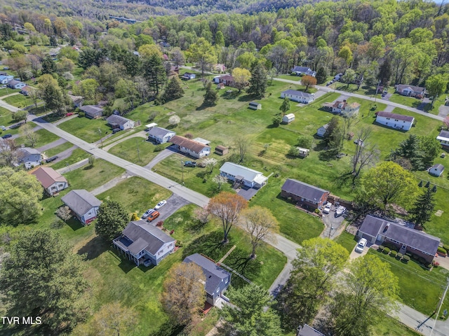 aerial view of property's location featuring a heavily wooded area and nearby suburban area