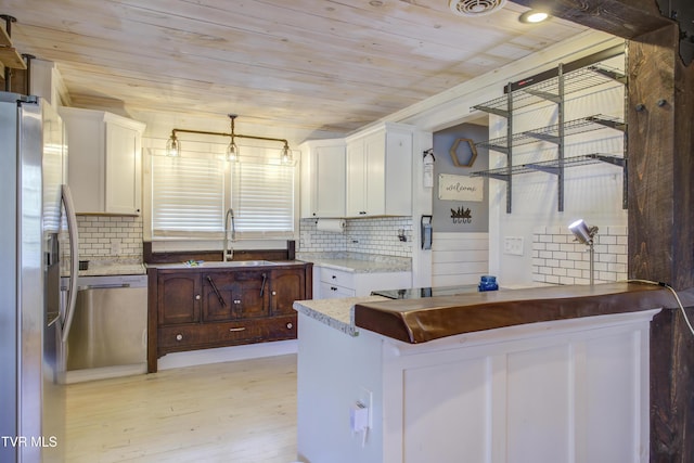 kitchen featuring appliances with stainless steel finishes, a sink, wood ceiling, light wood finished floors, and white cabinets