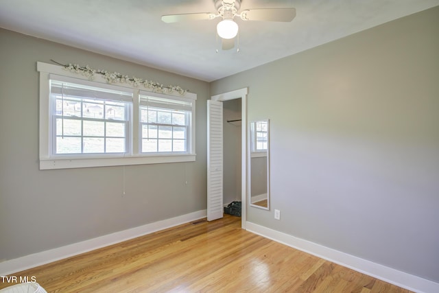unfurnished bedroom with baseboards, light wood finished floors, a closet, and ceiling fan