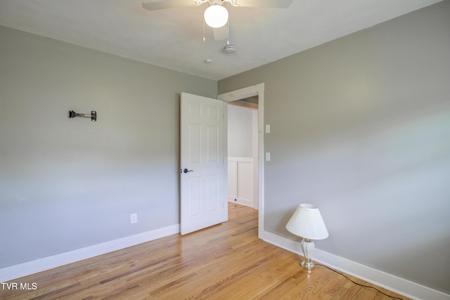 spare room featuring ceiling fan, light wood-type flooring, baseboards, and a smoke detector
