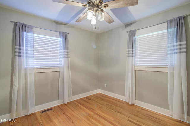 spare room with ceiling fan, light wood-style flooring, and baseboards