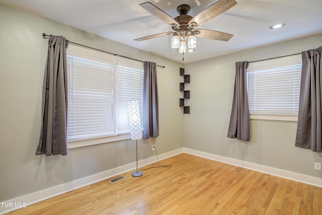 empty room with baseboards, light wood-style flooring, healthy amount of natural light, and recessed lighting
