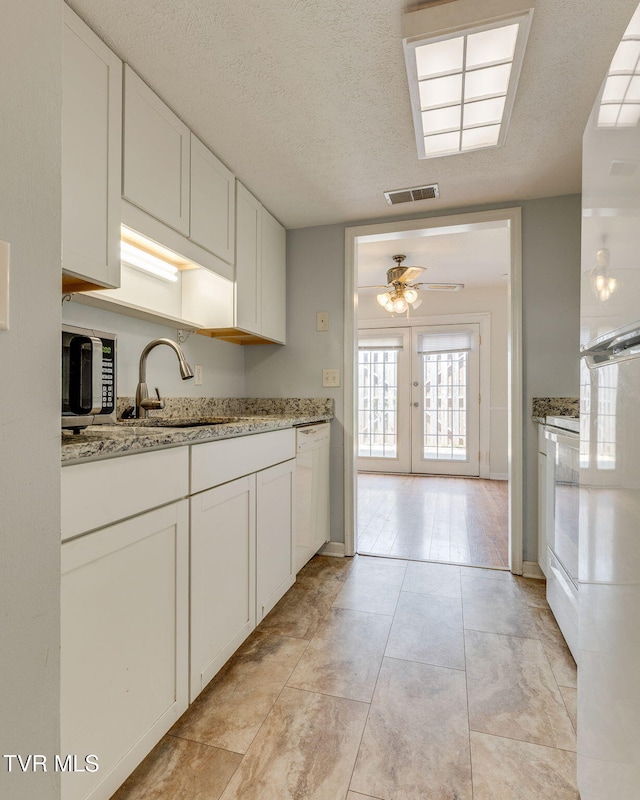 515 Pilgrim Ct Unit B, Johnson City, TN 37601 - kitchen featuring white dishwasher, a sink, a ceiling fan, white cabinets, and light stone counters