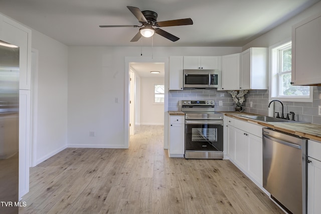 2116 Steadman St, Kingsport, TN 37664 - kitchen with stainless steel appliances, wooden counters, light wood-style flooring, and tasteful backsplash