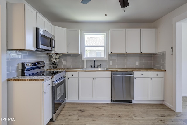 2116 Steadman St, Kingsport, TN 37664 - kitchen featuring appliances with stainless steel finishes, a sink, white cabinetry, light wood finished floors, and butcher block counters