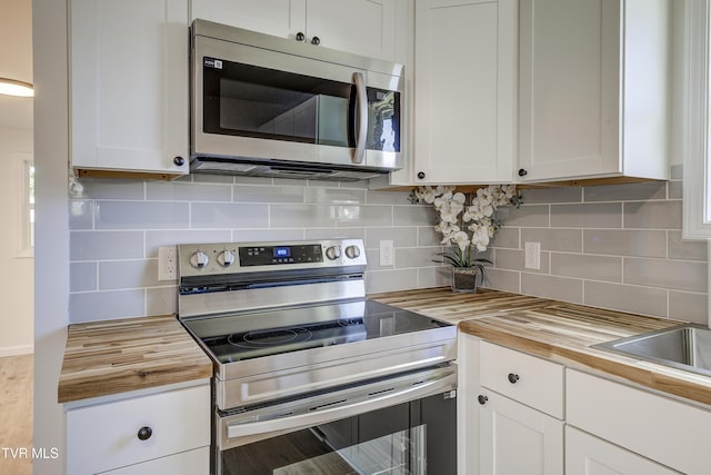 2116 Steadman St, Kingsport, TN 37664 - kitchen with stainless steel appliances, wooden counters, tasteful backsplash, and white cabinetry