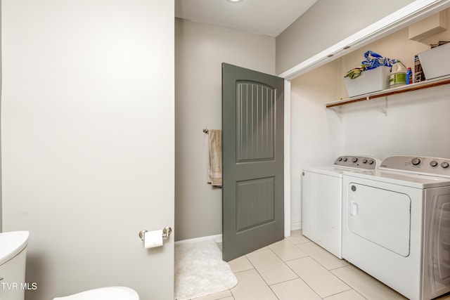 clothes washing area with separate washer and dryer and light tile patterned flooring