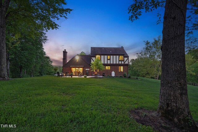 150 NW New Melrose St, Coeburn, VA 24230 - rear view of property featuring a chimney, a yard, brick siding, and a patio area