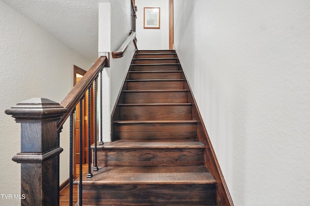 150 NW New Melrose St, Coeburn, VA 24230 - staircase with a textured wall, a textured ceiling, and wood finished floors