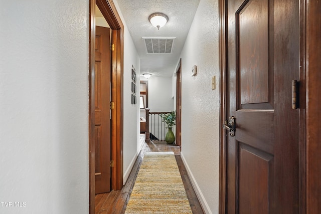 150 NW New Melrose St, Coeburn, VA 24230 - hall featuring a textured wall, wood finished floors, a textured ceiling, baseboards, and an upstairs landing