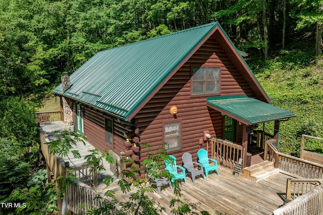 109 Hatley Hollow Rd, Butler, TN 37640 - view of front facade featuring a deck, metal roof, log exterior, a forest view, and a chimney