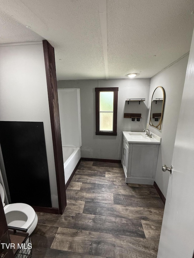 104 Creekbank Rd, Elizabethton, TN 37643 - bathroom with a textured ceiling, wood finished floors, vanity, toilet, and a tub to relax in