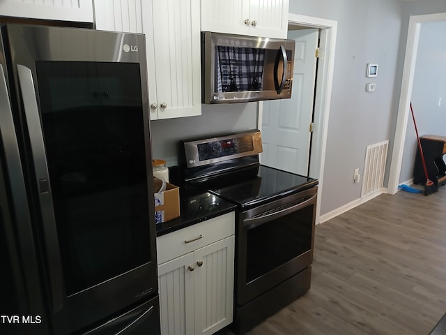 1318 Willow St, Kingsport, TN 37664 - kitchen featuring appliances with stainless steel finishes, baseboards, dark wood-style floors, white cabinetry, and dark countertops