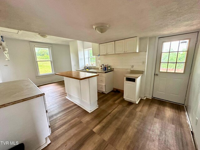 919 Russell St, Bristol, VA 24201 - kitchen with dark wood finished floors, white cabinetry, a textured ceiling, a kitchen island, and baseboards