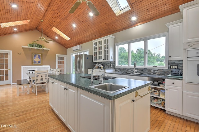 15497 Porterfield Hwy, Abingdon, VA 24210 - kitchen featuring a skylight, dark countertops, a sink, white oven, and vaulted ceiling