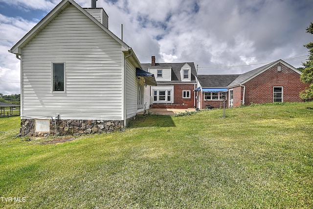 15497 Porterfield Hwy, Abingdon, VA 24210 - rear view of house featuring a lawn, brick siding, and a chimney