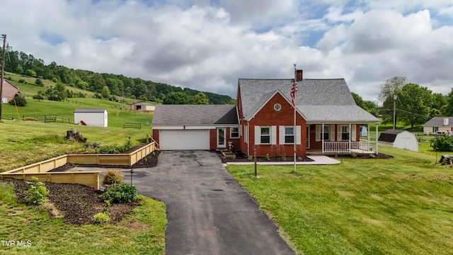15497 Porterfield Hwy, Abingdon, VA 24210 - view of front facade featuring a storage shed, an attached garage, asphalt driveway, a chimney, and covered porch