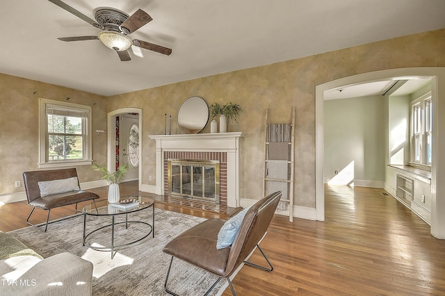 15497 Porterfield Hwy, Abingdon, VA 24210 - living room featuring arched walkways, a ceiling fan, wood finished floors, and a brick fireplace