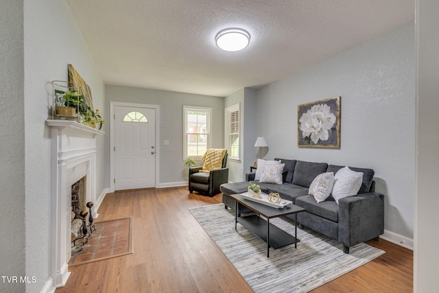 3224 Clover St, Kingsport, TN 37664 - living room featuring wood finished floors, a textured ceiling, baseboards, and a fireplace with flush hearth