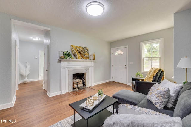 3224 Clover St, Kingsport, TN 37664 - living area with wood finished floors, a fireplace with flush hearth, a textured ceiling, and baseboards