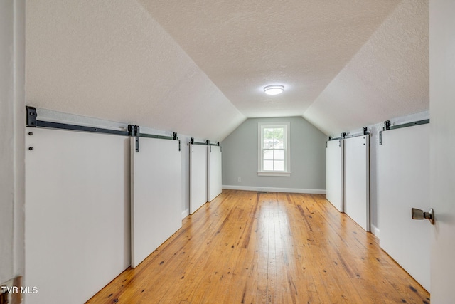 3224 Clover St, Kingsport, TN 37664 - additional living space featuring a barn door, a textured ceiling, light wood finished floors, and vaulted ceiling