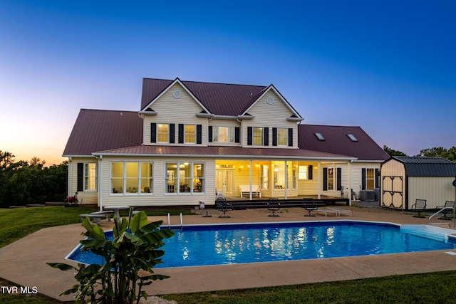 7540 Erwin Hwy, Chuckey, TN 37641 - back of property at dusk with a patio area, cooling unit, an outdoor pool, and metal roof