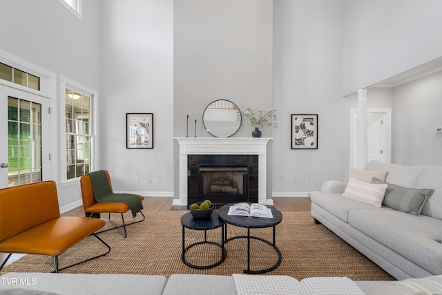 7540 Erwin Hwy, Chuckey, TN 37641 - living room featuring a high ceiling, wood finished floors, a tiled fireplace, and baseboards
