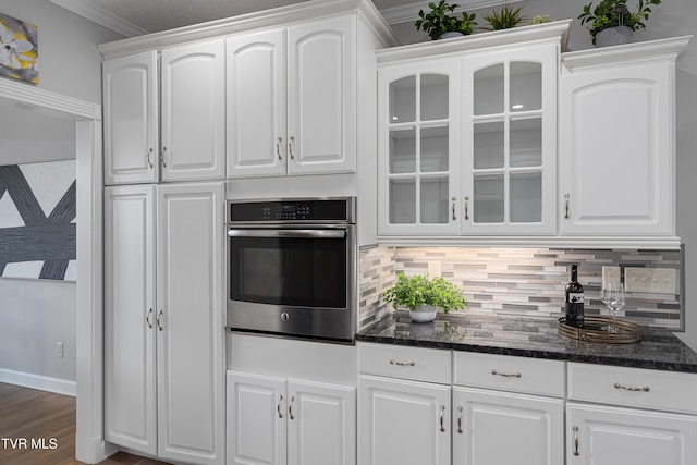 7540 Erwin Hwy, Chuckey, TN 37641 - kitchen featuring stainless steel oven, white cabinetry, decorative backsplash, and crown molding