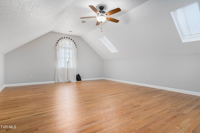 7540 Erwin Hwy, Chuckey, TN 37641 - additional living space with a skylight, ceiling fan, light wood-type flooring, lofted ceiling, and a textured ceiling
