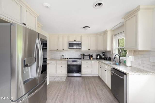 405 Castaway Dr, Kingsport, TN 37663 - kitchen with appliances with stainless steel finishes, cream cabinets, decorative backsplash, and light stone counters