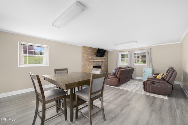405 Castaway Dr, Kingsport, TN 37663 - dining area with light wood-type flooring, a brick fireplace, baseboards, and crown molding