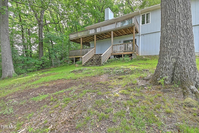 back of house featuring a deck, a chimney, and stairs