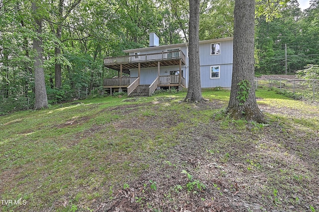 back of house featuring a deck, fence, a chimney, and stairs