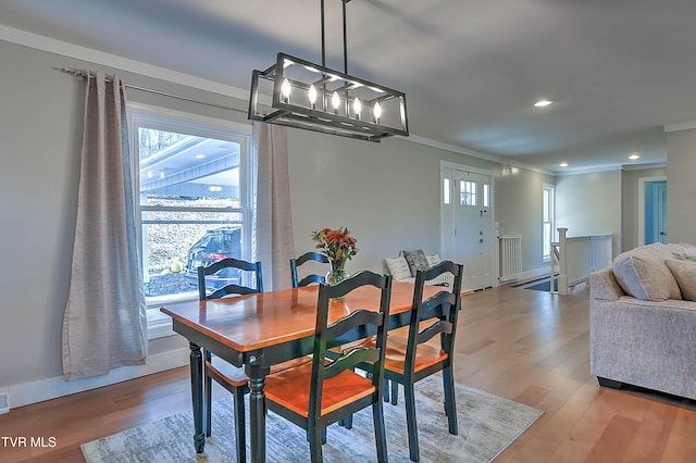 dining area featuring wood finished floors, ornamental molding, a chandelier, recessed lighting, and baseboards