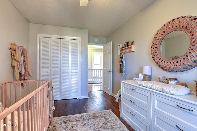 bedroom with a closet, dark wood-style flooring, and baseboards