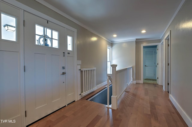 foyer entrance with ornamental molding, wood finished floors, baseboards, and recessed lighting