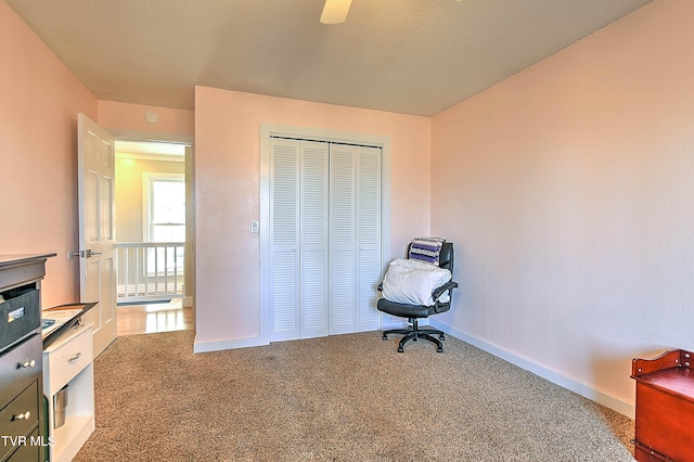 unfurnished office with carpet flooring, baseboards, and ceiling fan