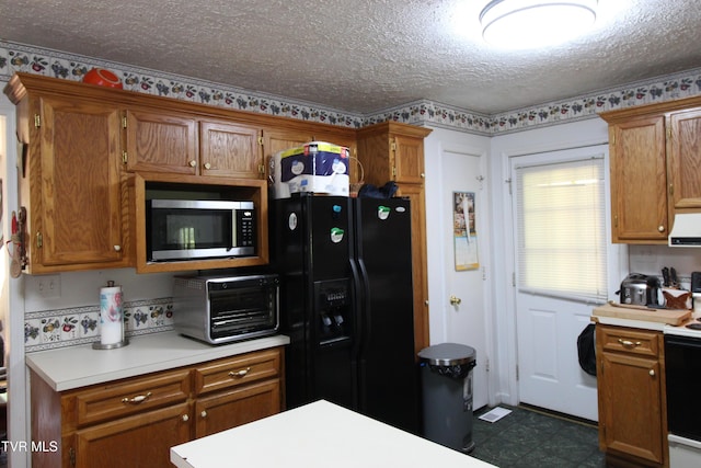 16319 Mary St, Abingdon, VA 24210 - kitchen featuring stainless steel microwave, black fridge, light countertops, brown cabinets, and a textured ceiling