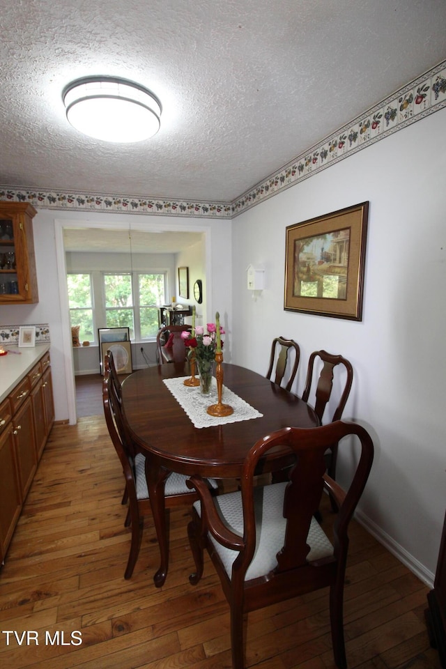 16319 Mary St, Abingdon, VA 24210 - dining room with light wood-style flooring, a textured ceiling, and baseboards