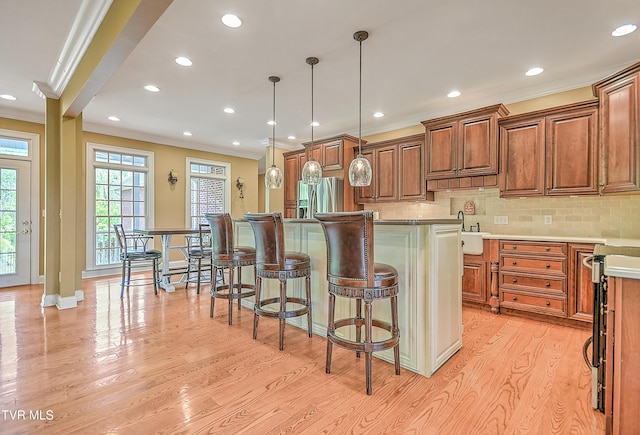 2041 King College Rd, Bristol, TN 37620 - kitchen featuring crown molding, light wood-type flooring, plenty of natural light, tasteful backsplash, and a kitchen breakfast bar