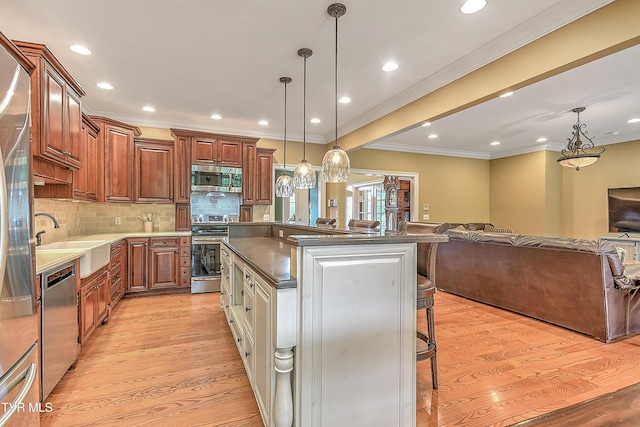 2041 King College Rd, Bristol, TN 37620 - kitchen with appliances with stainless steel finishes, a sink, a breakfast bar area, crown molding, and a kitchen island