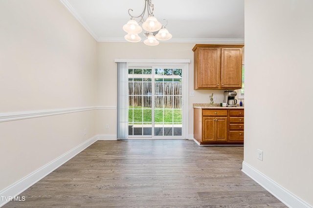 614 N Center St Unit 5, Johnson City, TN 37604 - unfurnished dining area with a chandelier, crown molding, light wood-style flooring, and baseboards