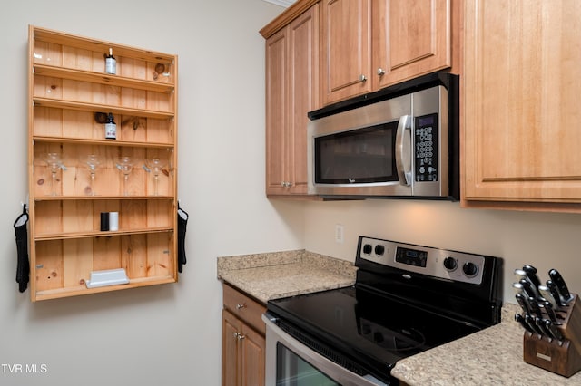 614 N Center St Unit 5, Johnson City, TN 37604 - kitchen featuring appliances with stainless steel finishes, open shelves, and light stone countertops