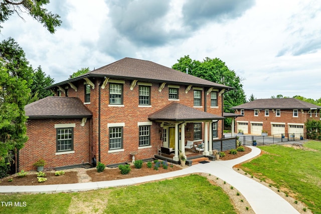 2107 Bartlett St, Johnson City, TN 37601 - colonial inspired home featuring a front lawn, a shingled roof, brick siding, a garage, and covered porch
