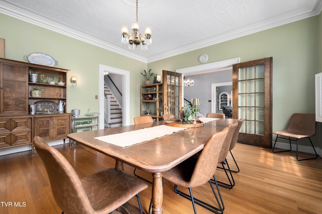 2107 Bartlett St, Johnson City, TN 37601 - dining room with a chandelier, light wood finished floors, stairway, ornamental molding, and a textured ceiling