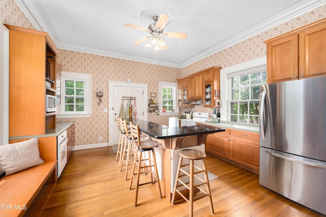2107 Bartlett St, Johnson City, TN 37601 - kitchen with white appliances, wallpapered walls, plenty of natural light, light wood-style floors, and a breakfast bar area