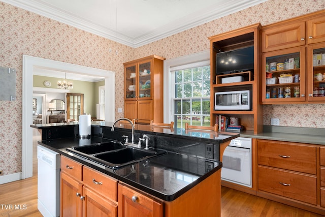 2107 Bartlett St, Johnson City, TN 37601 - kitchen featuring wallpapered walls, white appliances, a sink, brown cabinets, and a center island with sink