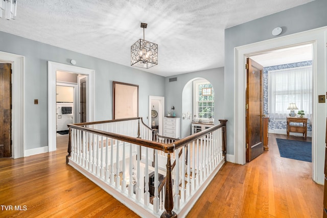2107 Bartlett St, Johnson City, TN 37601 - hall featuring wood finished floors, an upstairs landing, a textured ceiling, and baseboards