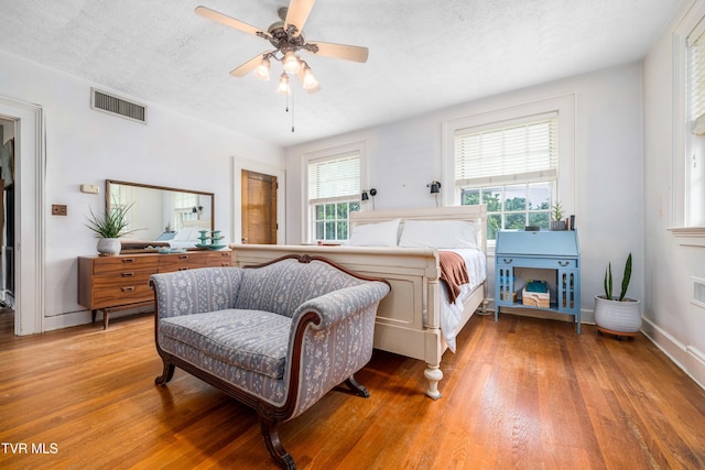 2107 Bartlett St, Johnson City, TN 37601 - bedroom featuring multiple windows, light wood-style flooring, ceiling fan, a textured ceiling, and baseboards